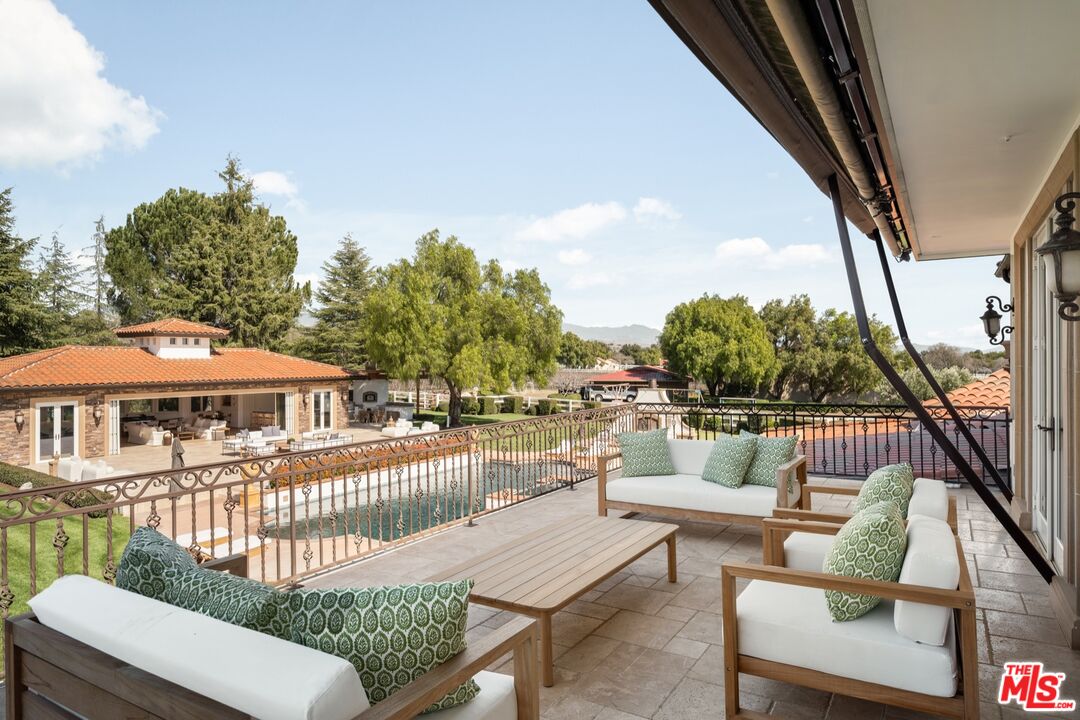 2370 North Refugio Road Santa Ynez, CA 93460 - Photo 17 of 66 a view of a patio with couches table and chairs under an umbrella with a small yard