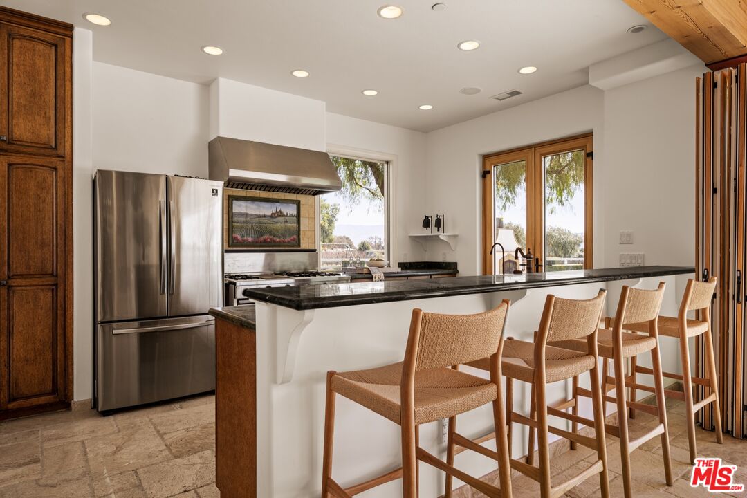 2370 North Refugio Road Santa Ynez, CA 93460 - Photo 38 of 66 a kitchen with stainless steel appliances granite countertop a refrigerator and a stove top oven