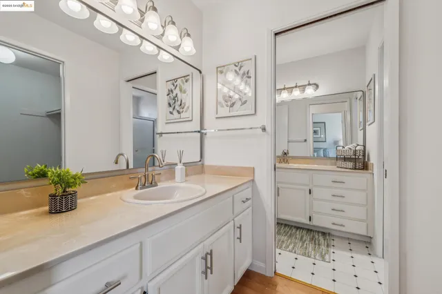 a bathroom with a sink a large mirror and shower