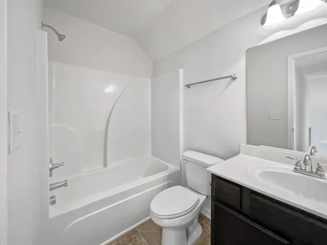 a bathroom with a sink toilet vanity and shower