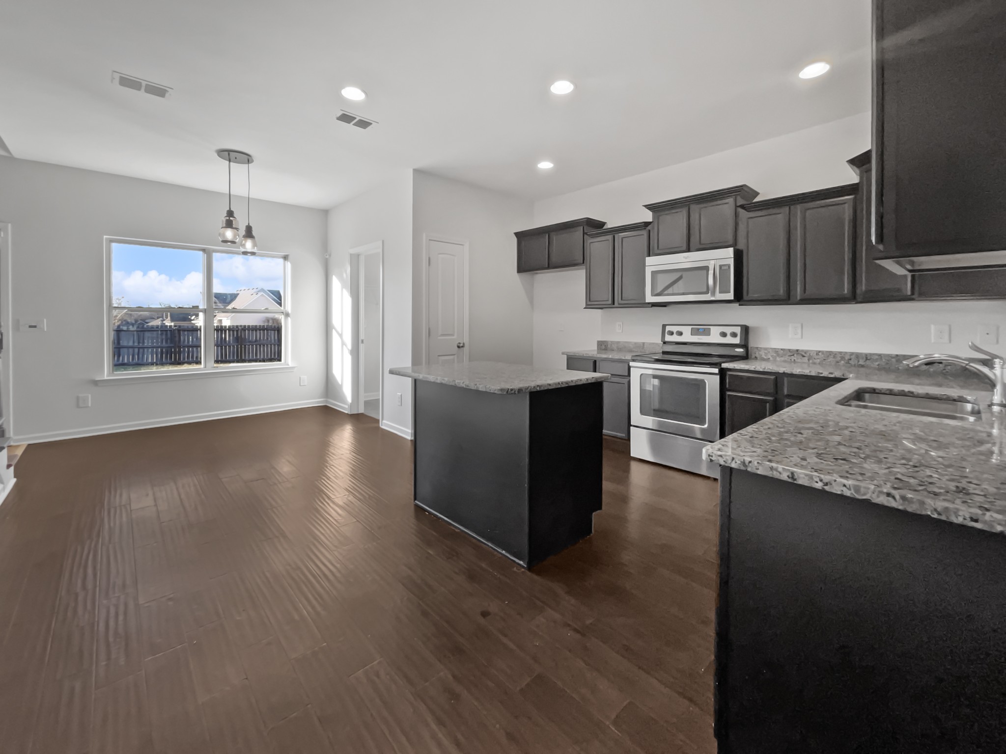 5020 Norman Way Spring Hill, TN 37174 - Photo 5 of 18 a kitchen with stainless steel appliances granite countertop a stove top oven a sink dishwasher and a microwave oven on the wooden floor