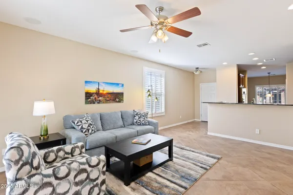 a living room with furniture and a ceiling fan