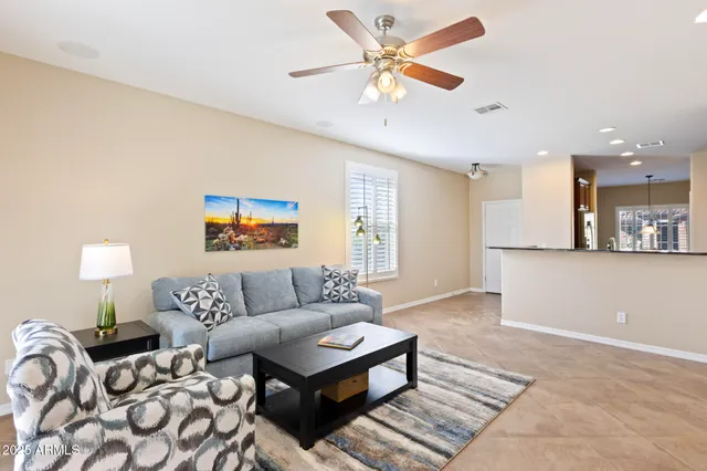 a living room with furniture and a ceiling fan