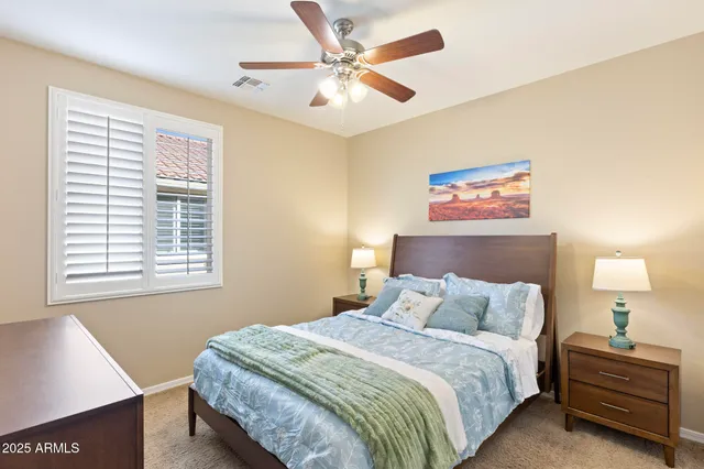 a bedroom with a bed and a painting on the wall