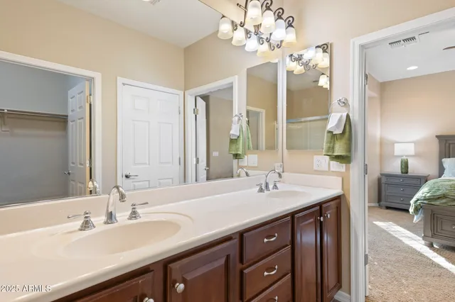 a spacious bathroom with double vanity and a mirror