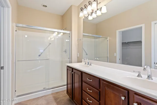 a bathroom with a double vanity sink mirror and shower