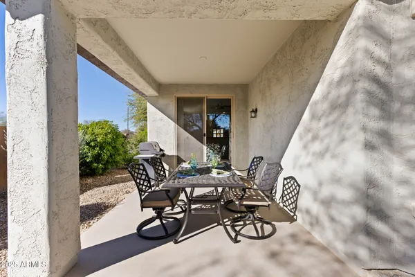 a view of a patio with table and chairs and potted plants