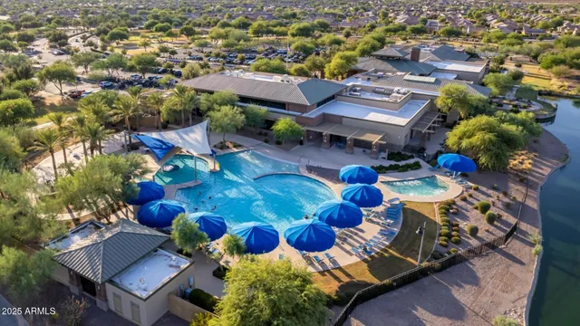 a view of a house with pool and lawn chairs