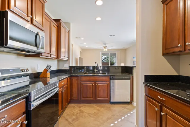 a kitchen with stainless steel appliances granite countertop a stove a sink and a microwave
