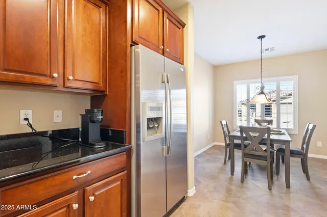 a kitchen with stainless steel appliances granite countertop a refrigerator a sink a stove and white cabinets