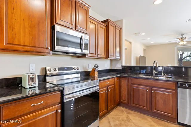 a kitchen with stainless steel appliances granite countertop a sink stove and microwave