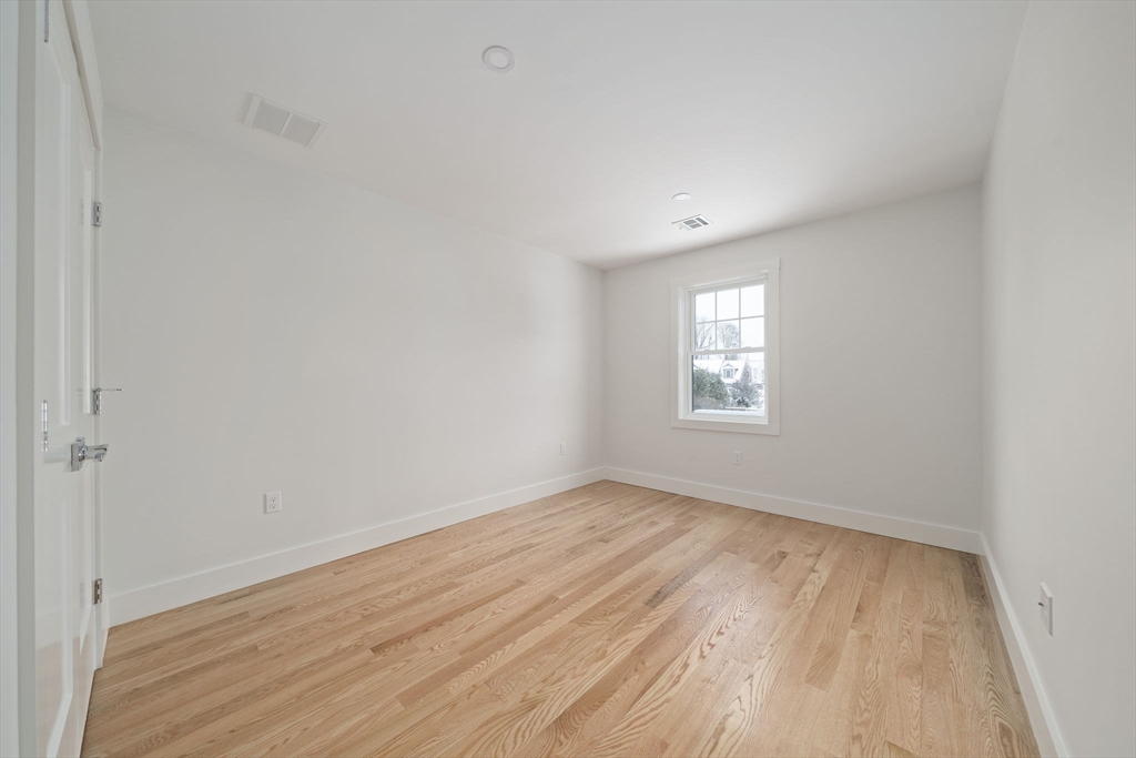 87 Neponset Street, Unit 87 Canton, MA 02021 - Photo 19 of 22 a view of an empty room with wooden floor and a window