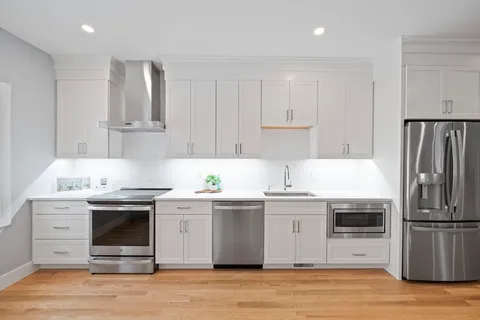 a kitchen with stainless steel appliances granite countertop a stove a sink and a refrigerator