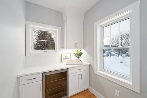 a kitchen with a window wooden cabinets and wooden floor