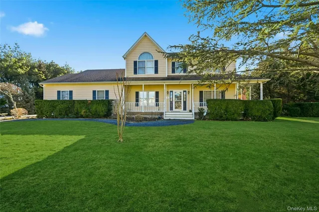 a view of house with a big yard and potted plants and large trees