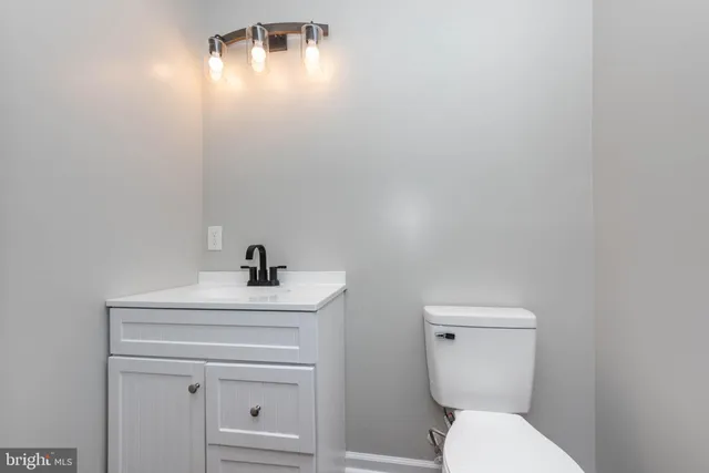 a bathroom with a sink a toilet and mirror