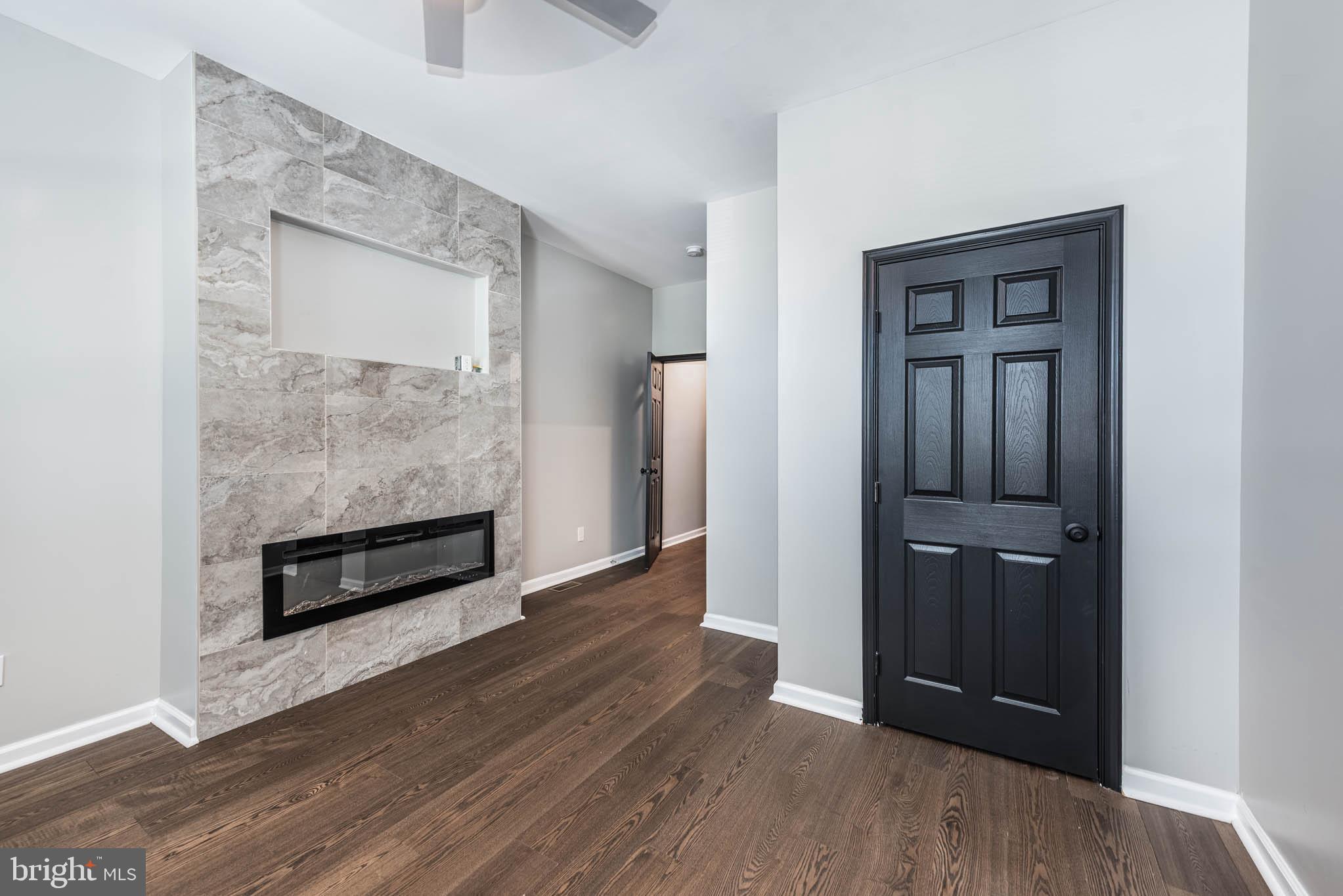 1715 East Oliver Street Baltimore, MD 21213 - Photo 13 of 30 an empty room with wooden floor cabinet and windows