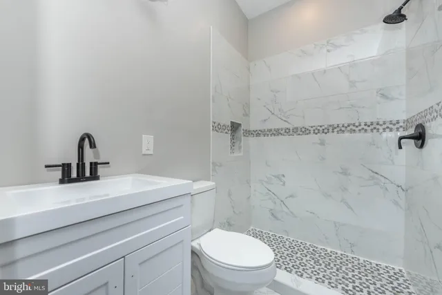 a bathroom with a sink a toilet and shower