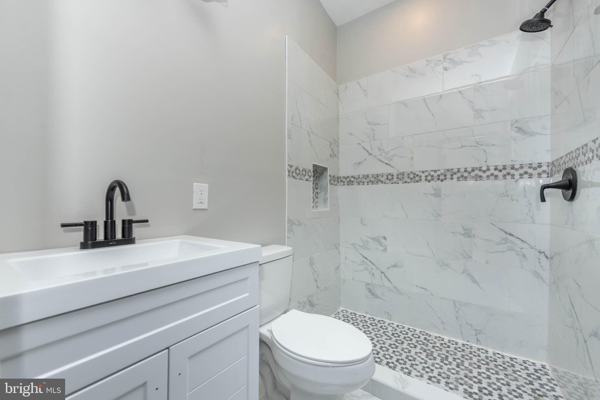 1715 East Oliver Street Baltimore, MD 21213 - Photo 14 of 30 a bathroom with a sink a toilet and shower