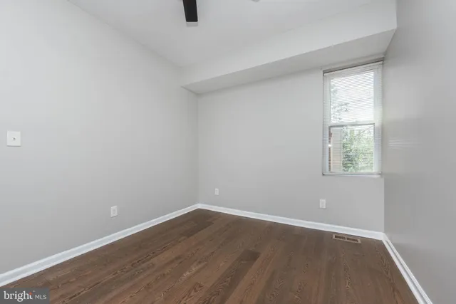 a view of a small space with wooden floor and a window