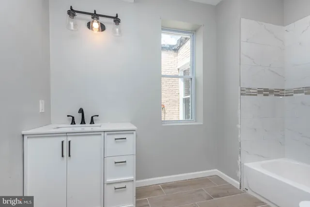a view of bathroom with bathtub cabinet and window