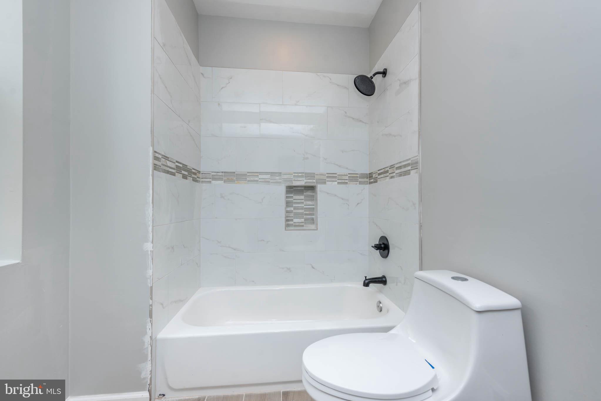 1715 East Oliver Street Baltimore, MD 21213 - Photo 19 of 30 a bathroom with a toilet and a bath tub