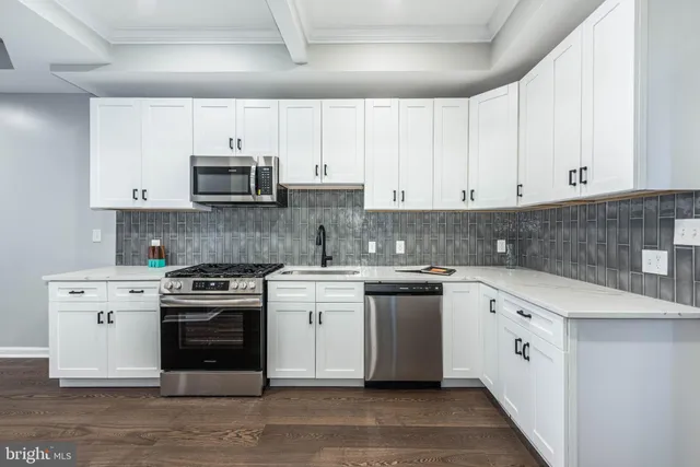 a kitchen with stainless steel appliances granite countertop a stove a sink and a microwave