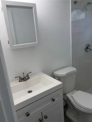 a bathroom with a sink mirror and toilet