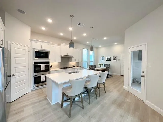 a large kitchen with a table and chairs