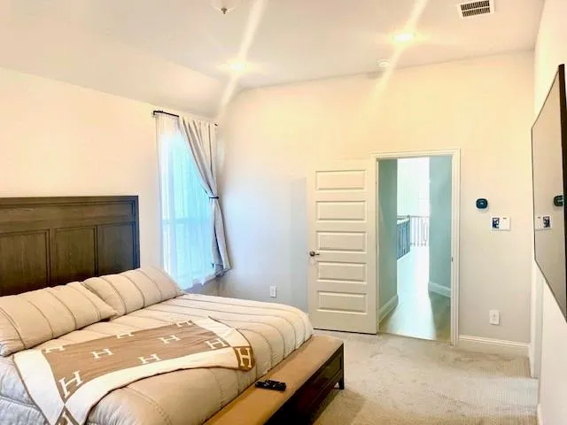 a bedroom with a large bed and a chandelier