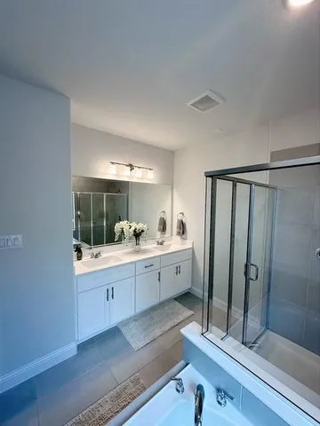 a large bathroom with a double vanity sink a large mirror and shower