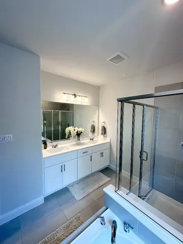 a large bathroom with a double vanity sink a large mirror and shower