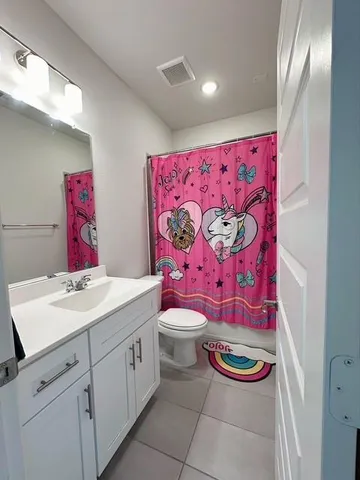a bathroom with a sink toilet vanity and curtain