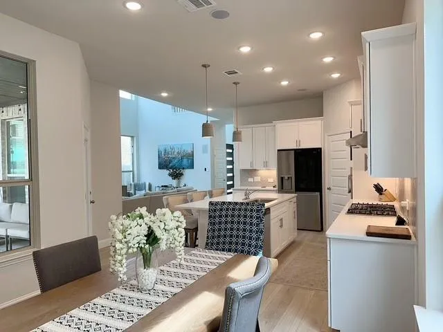 a kitchen with granite countertop kitchen island stainless steel appliances a sink and a living room view