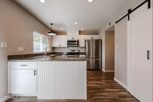 a kitchen with stainless steel appliances granite countertop a refrigerator and a stove