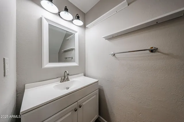 a bathroom with a sink mirror and vanity