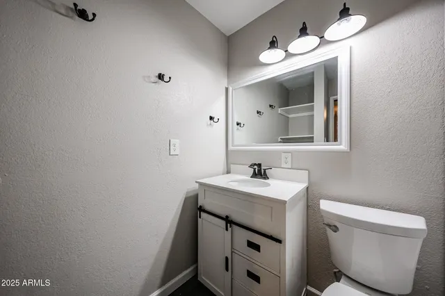 a bathroom with a toilet sink and mirror