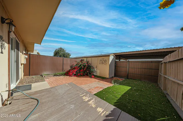 a backyard of a house with wooden floor and fence
