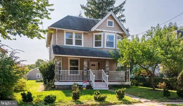 a front view of a house with a yard and potted plants