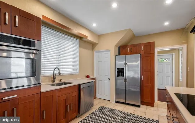 a kitchen with stainless steel appliances granite countertop a refrigerator and a sink