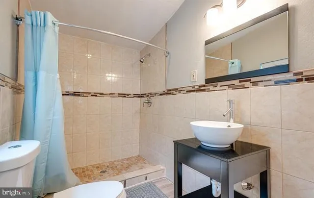 a bathroom with a toilet a sink and a mirror