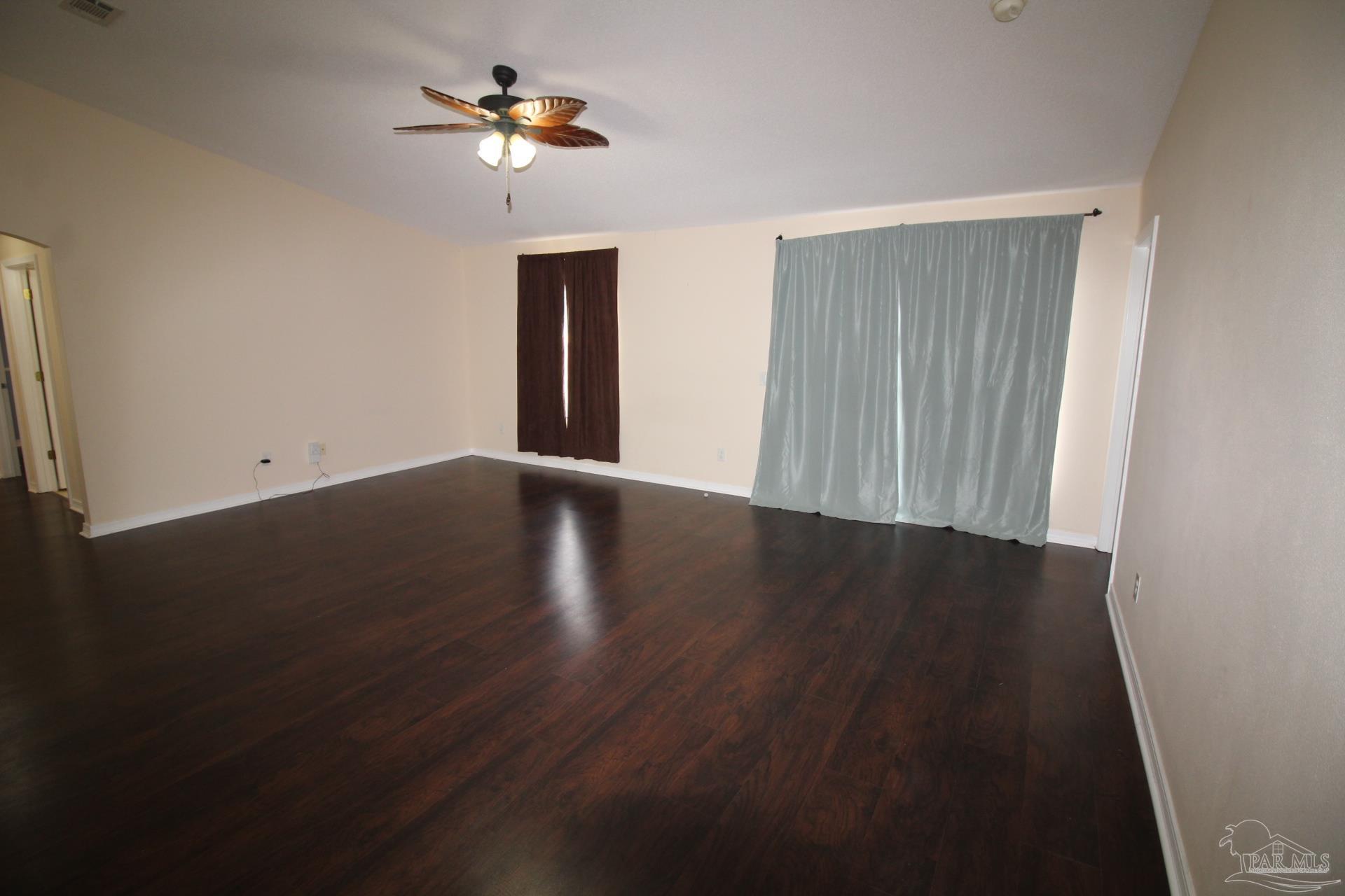 4564 Carmel Circle Pace, FL 32571 - Photo 2 of 16 a view of a livingroom with wooden floor and a ceiling fan