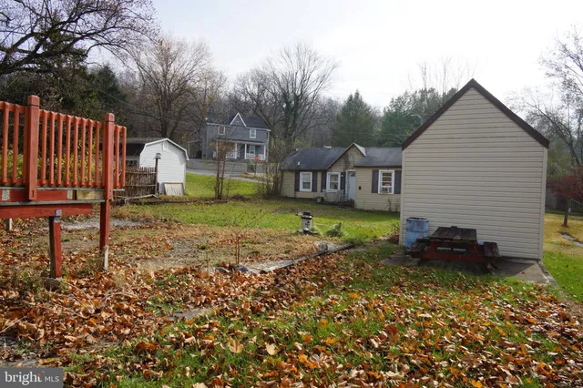 a backyard of a house with a garden and barbeque oven