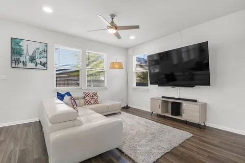 a living room with furniture and a wooden floor