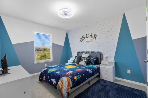 a bedroom with a bed and a painting on the wall