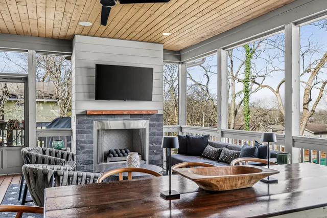 a living room with furniture a fireplace and a floor to ceiling window