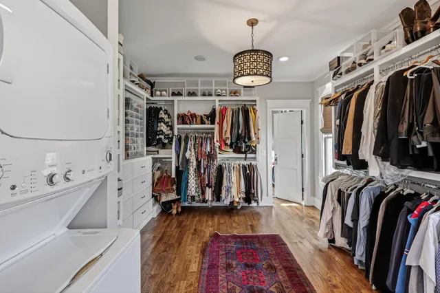 a view of walk in closet with clothes and shoes