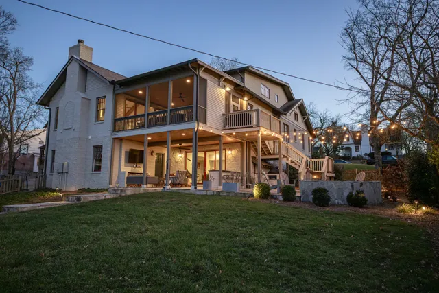 a view of a house with a big yard and large trees