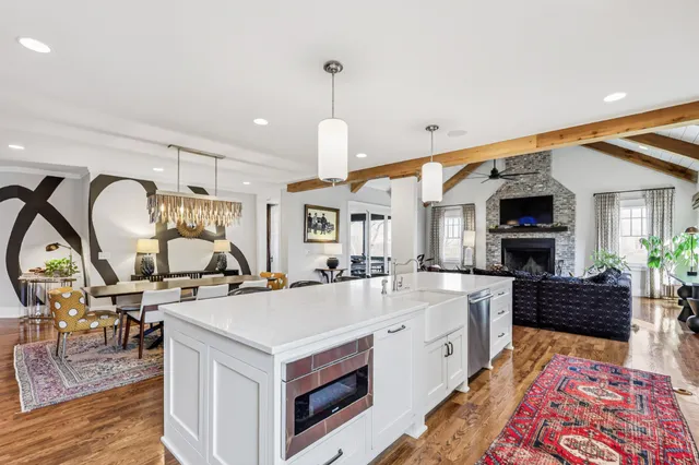 a open kitchen with stainless steel appliances granite countertop a stove and a wooden floors