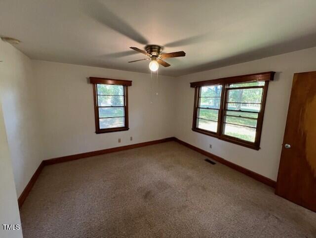 5629 Tabbs Creek Road Oxford, NC 27565 - Photo 29 of 40 an empty room with windows and ceiling fan